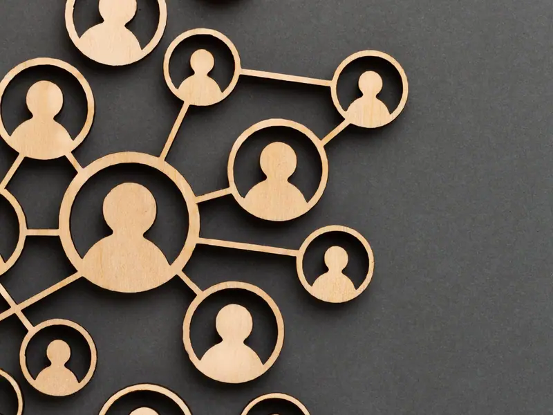 Wooden figures of people linked together in a network